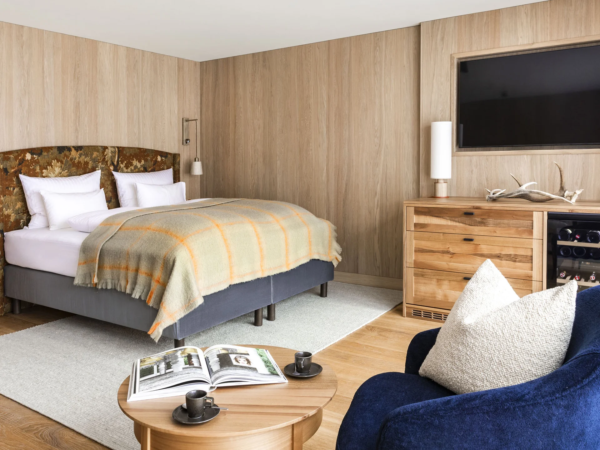 Gemütliches Schlafzimmer mit Holzverkleidung, Doppelbett und TV