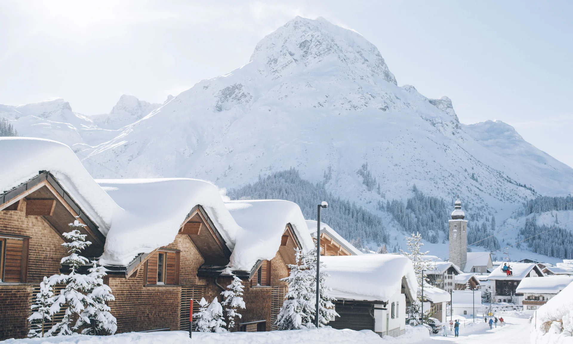 Schneebedeckte Häuser unter einem verschneiten Berg im Winter