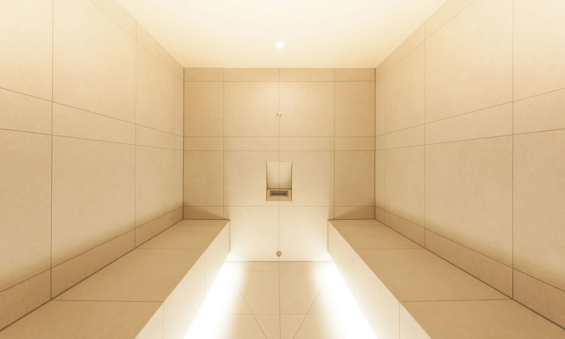 Minimalistisches beige gefliestes Duschzimmer mit eingebauter Bank und Beleuchtung