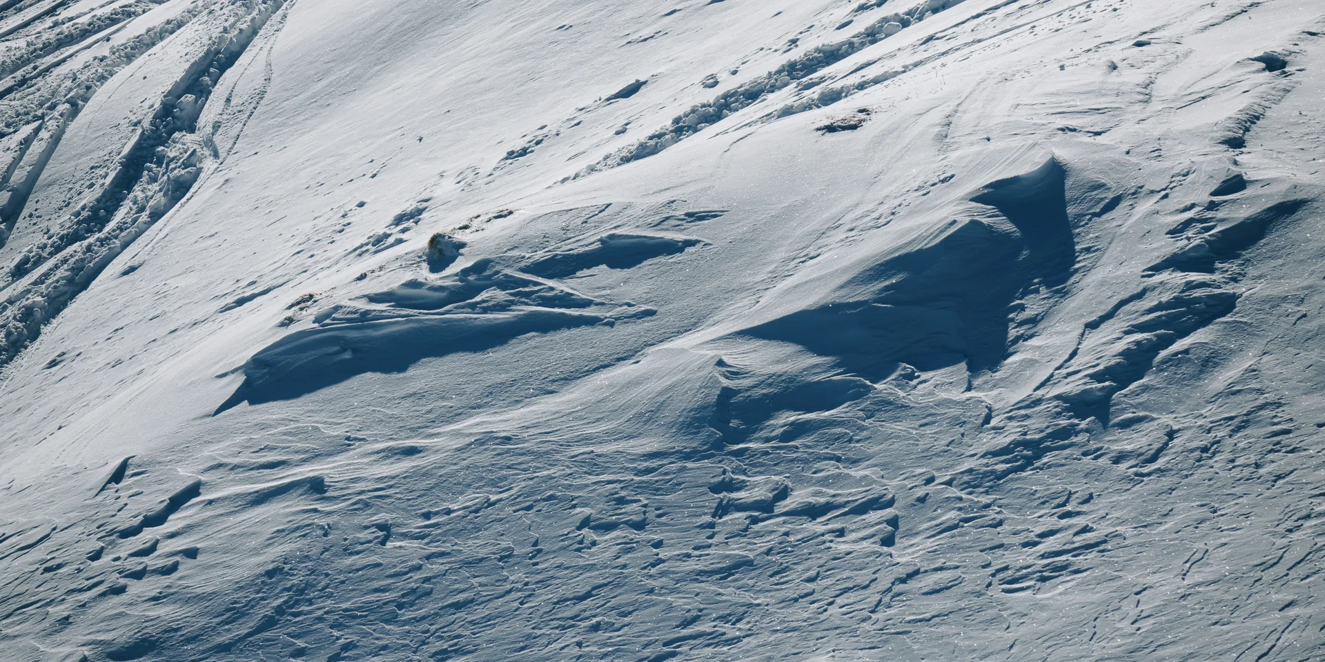 Verschneite Berghänge mit Spuren im frischen Schnee