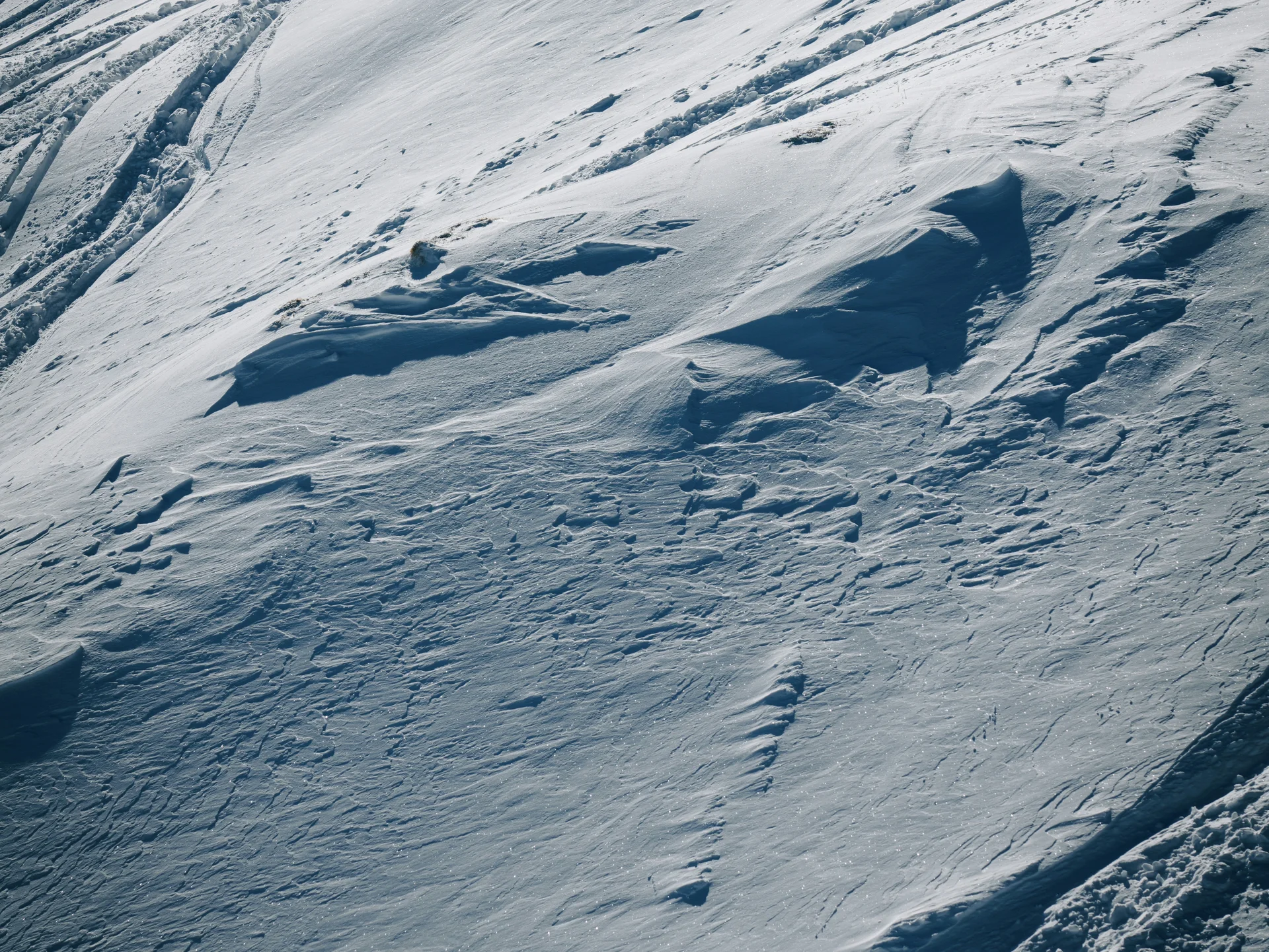 Verschneite Berghänge mit Spuren im frischen Schnee