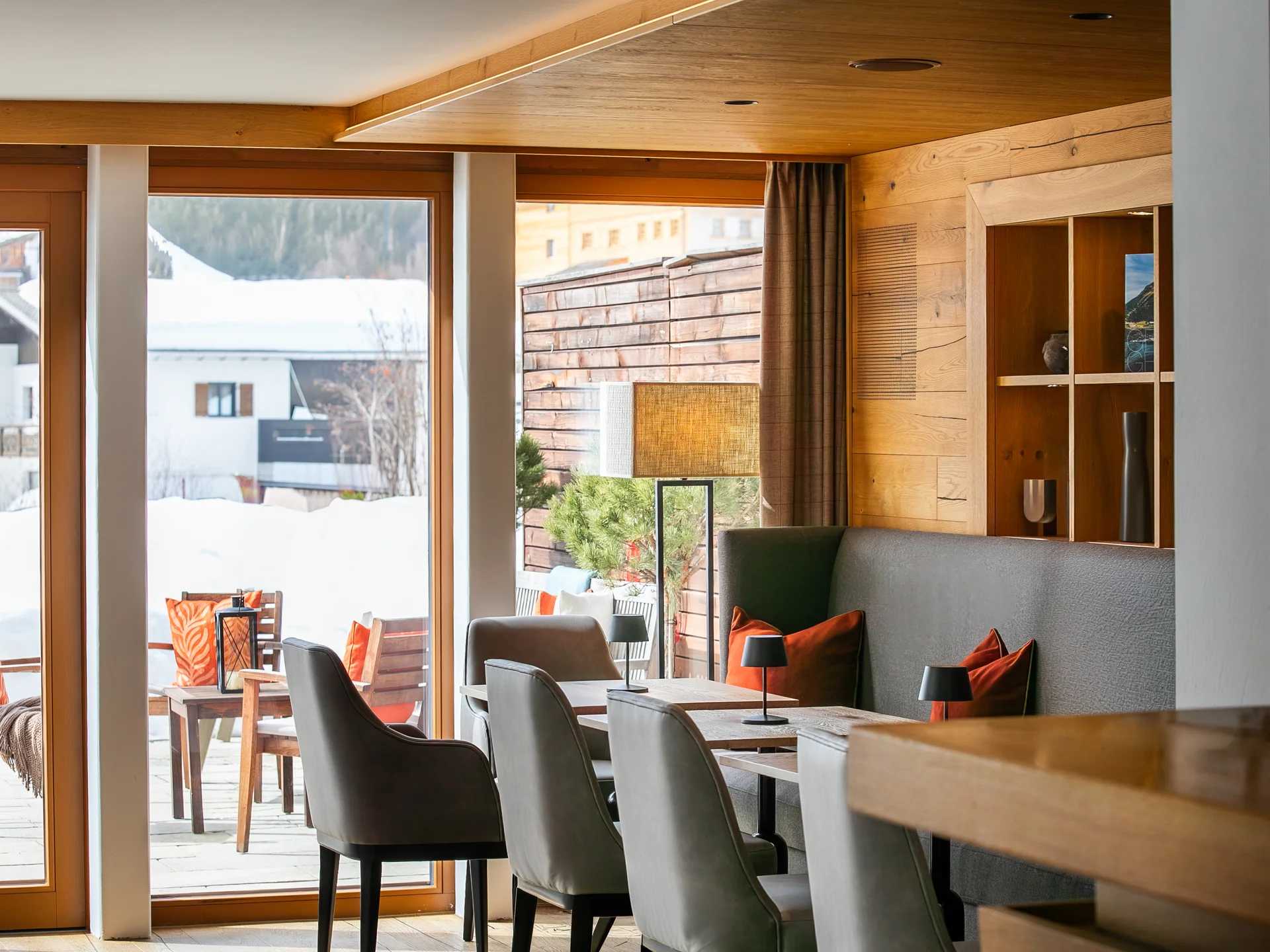 Moderner Gastraum mit Holzdecke und Sitzbereich neben großen Fenstern im Winter