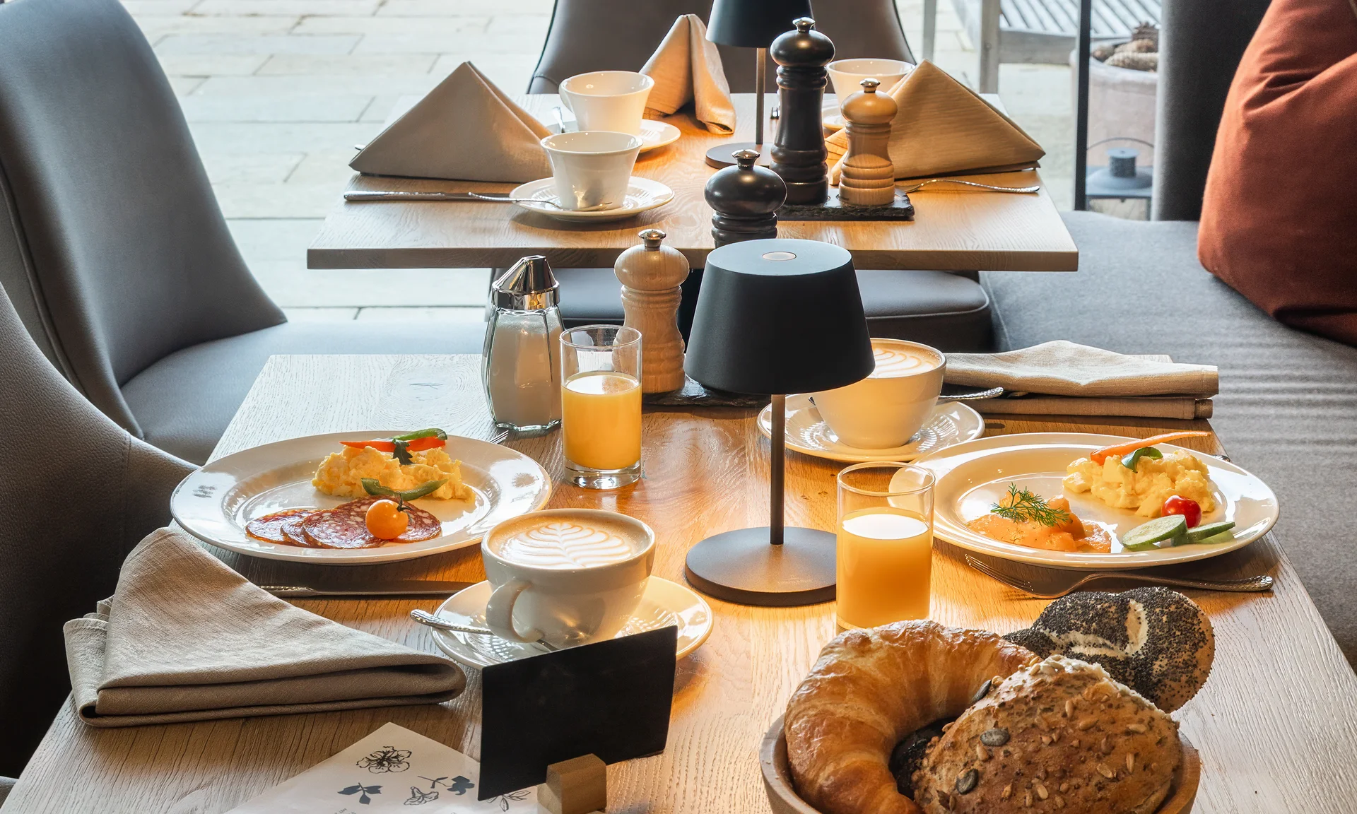 Bilder und Impressionen aus dem Sunora Frühstückstisch mit Kaffee, Säften, Gebäck und Besteck in gemütlichem Raum