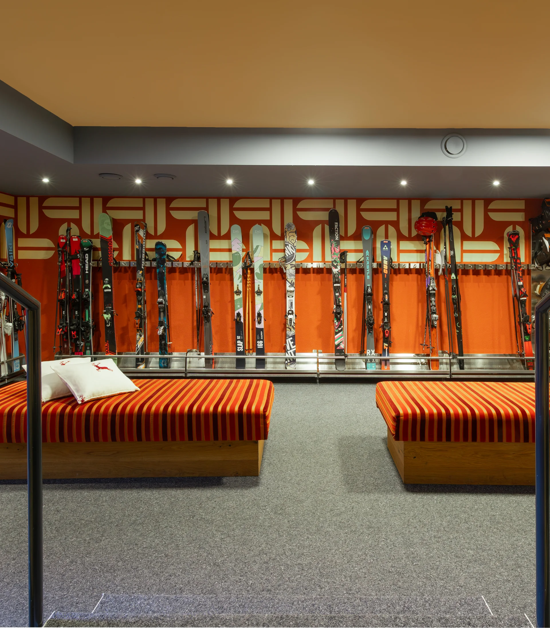 Skiaufbewahrung mit zwei roten Liegen in einem modernen Raum
