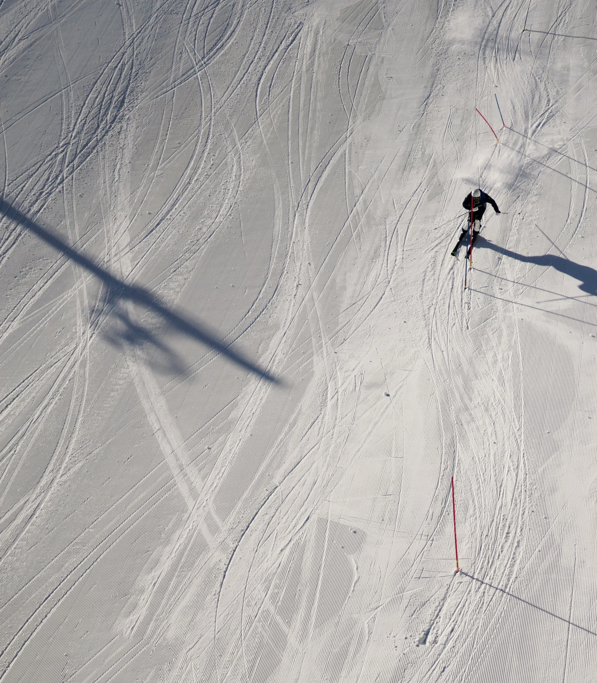 Ein Skifahrer fährt eine präparierte Piste aus der Vogelperspektive