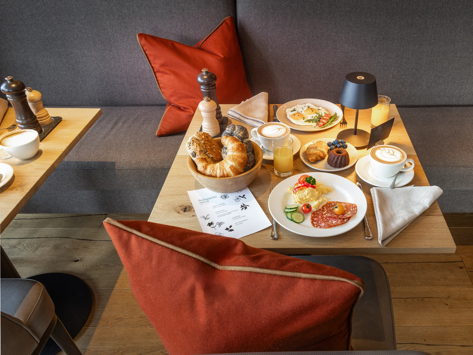 Bilder und Impressionen aus dem Sunora Frühstückstisch mit Brötchen, Eiern, Kaffee und Saft in gemütlicher Sitzecke