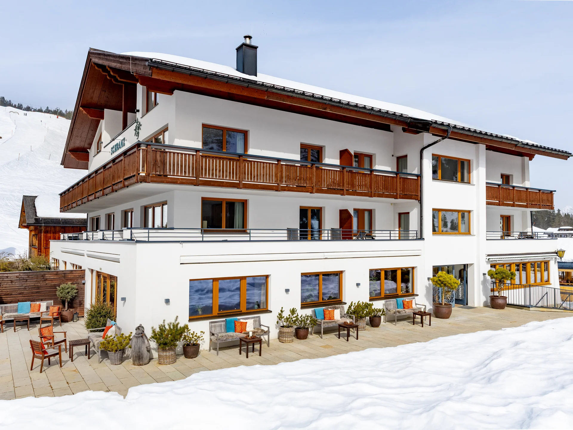 Bilder und Impressionen aus dem Sunora Mehrstöckiges Chalet mit Holzbalcon und Schnee im Winter
