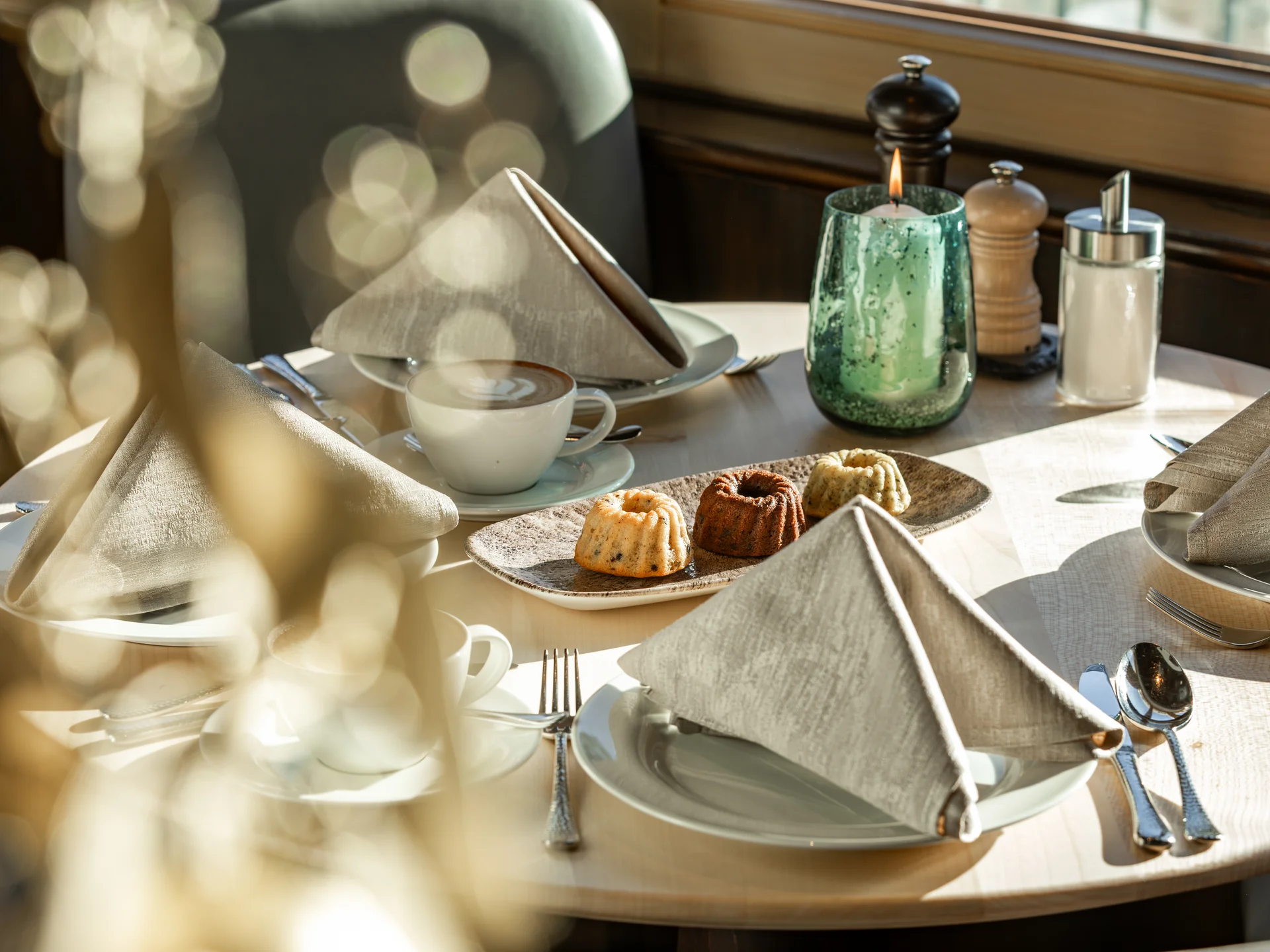 Bilder und Impressionen aus dem Sunora Eingedeckter Tisch mit Kaffee, Kuchen, Kerze und Gewürzen im Restaurant