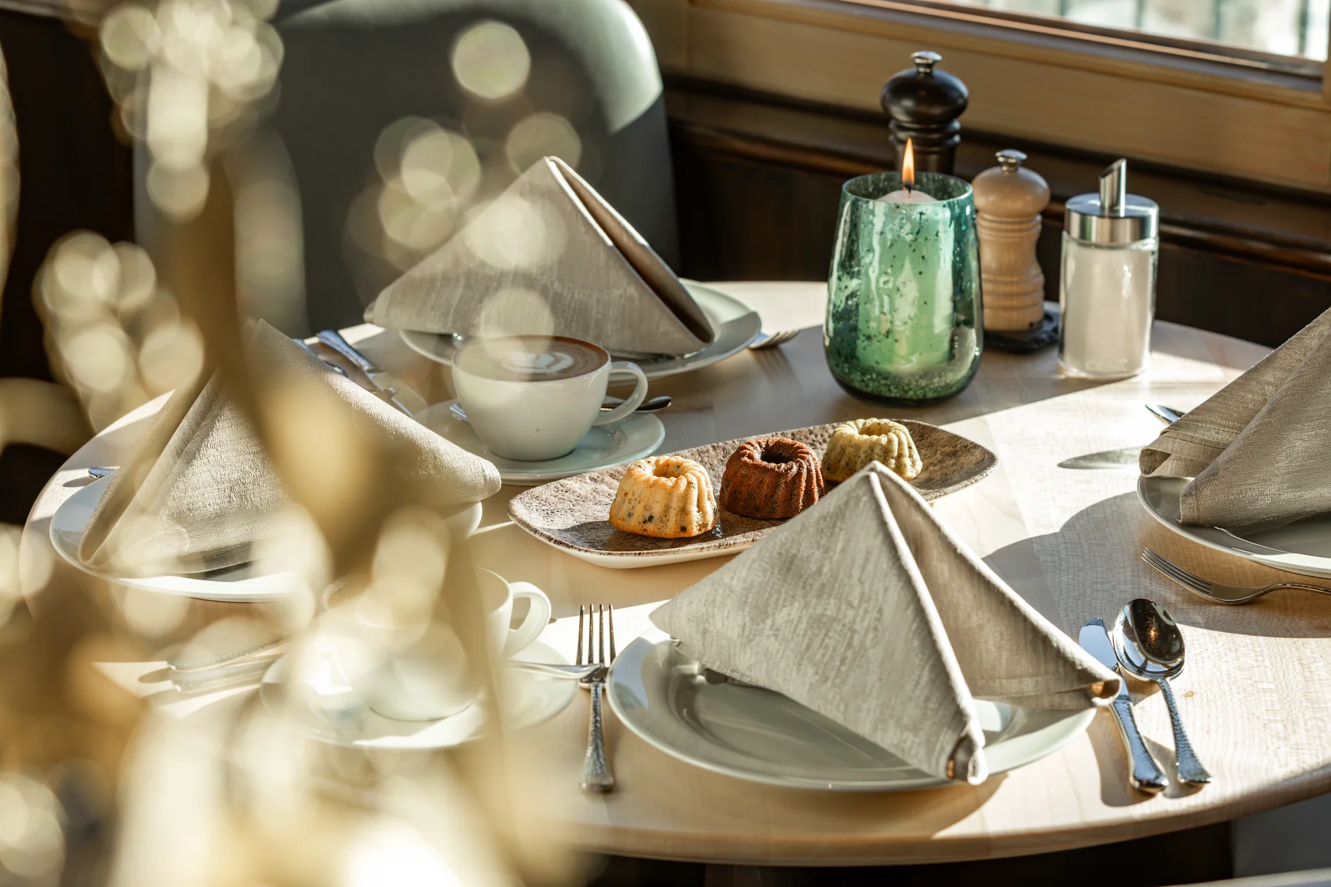 Eingedeckter Tisch mit Kaffee, Kuchen, Kerze und Gewürzen im Restaurant