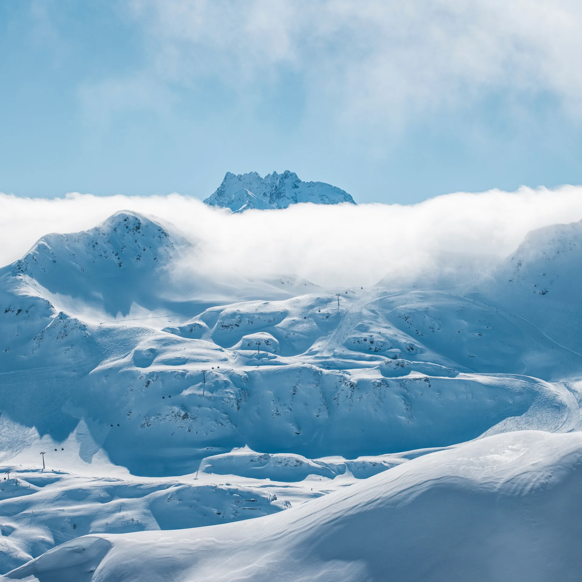 Schneebedeckte Berge mit Wolken und blauem Himmel im Hintergrund