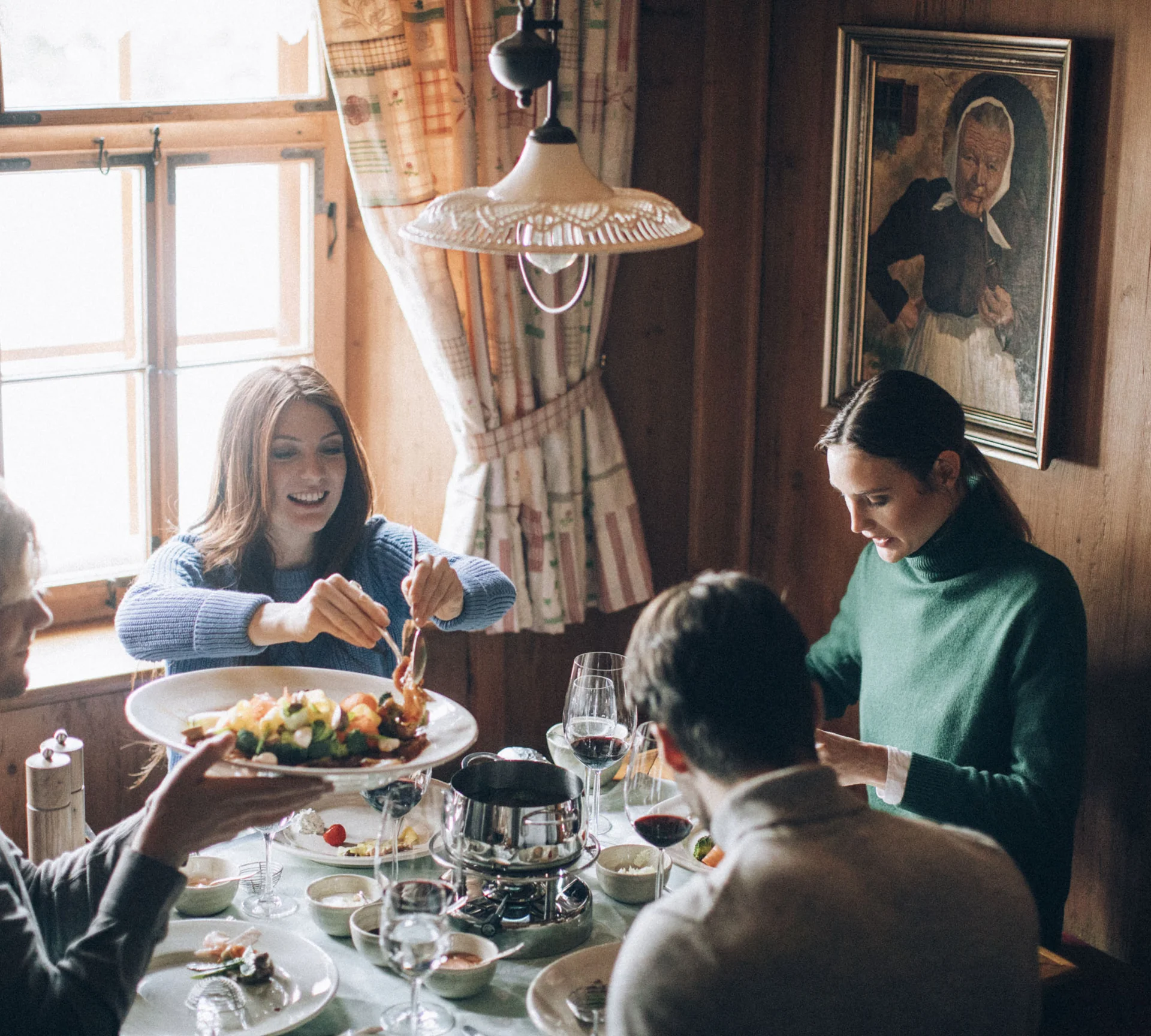 Gruppe von Menschen genießt gemeinsames Essen in rustikalem Raum