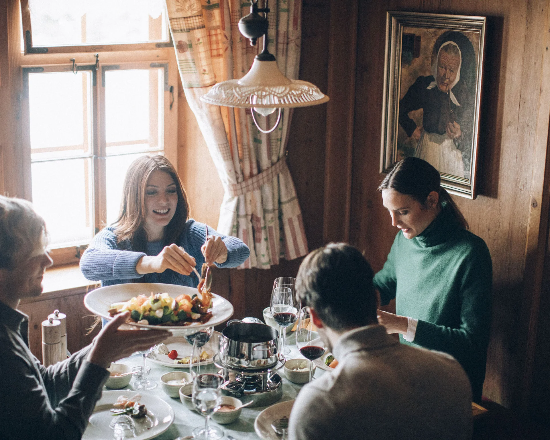 Gruppe von Menschen genießt gemeinsames Essen in rustikalem Raum