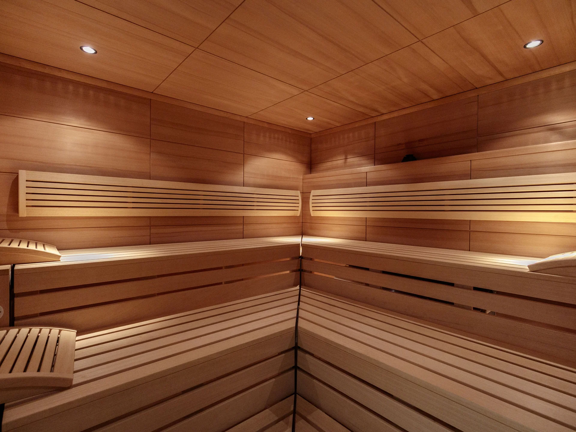 Innenansicht einer leeren Sauna mit Holzwänden und Sitzbänken