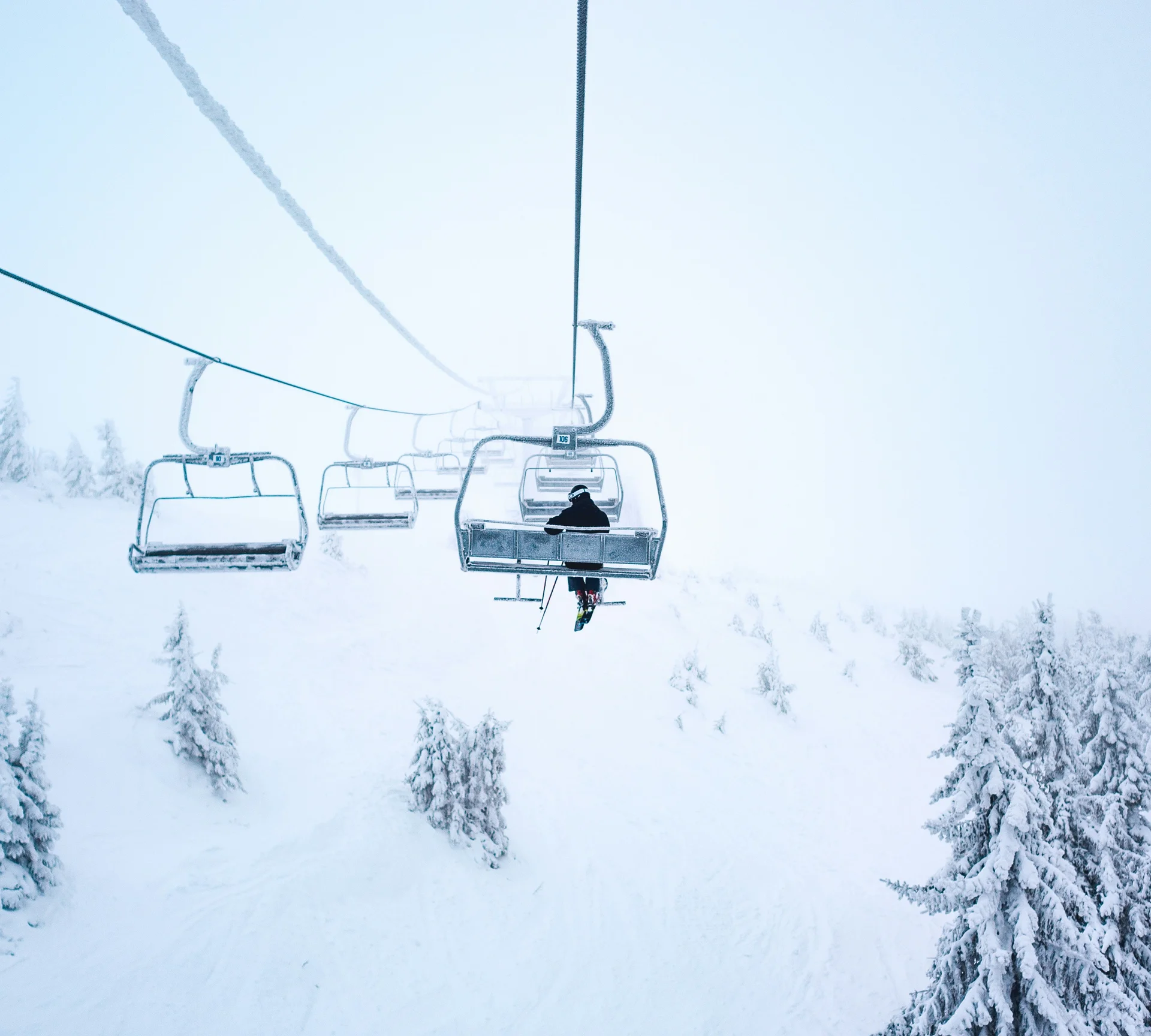Skilift mit eingeschneiten Bäumen in einer winterlichen Berglandschaft