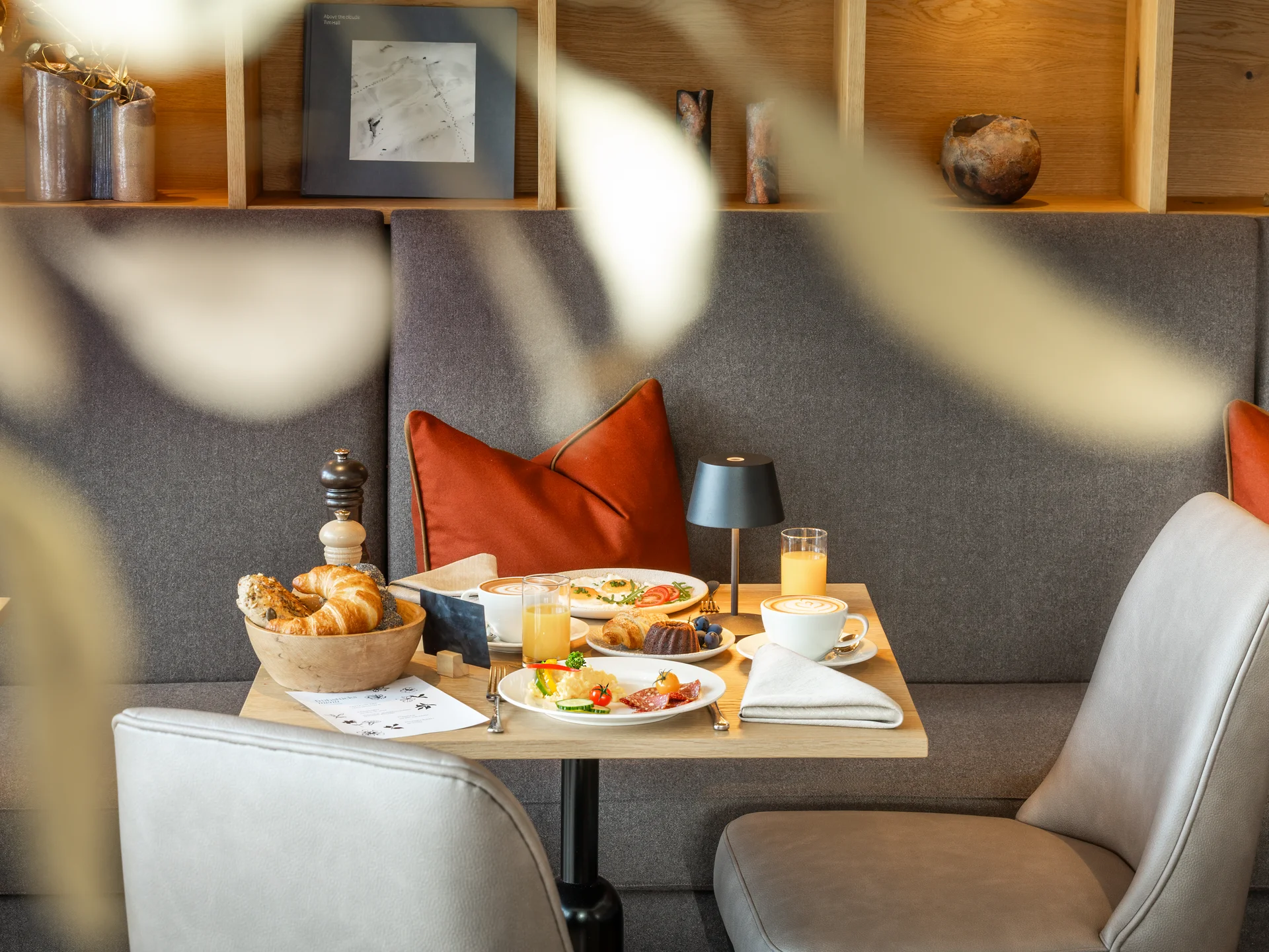 Gemütlicher Frühstückstisch mit Croissants und Saft in einem modernen Café